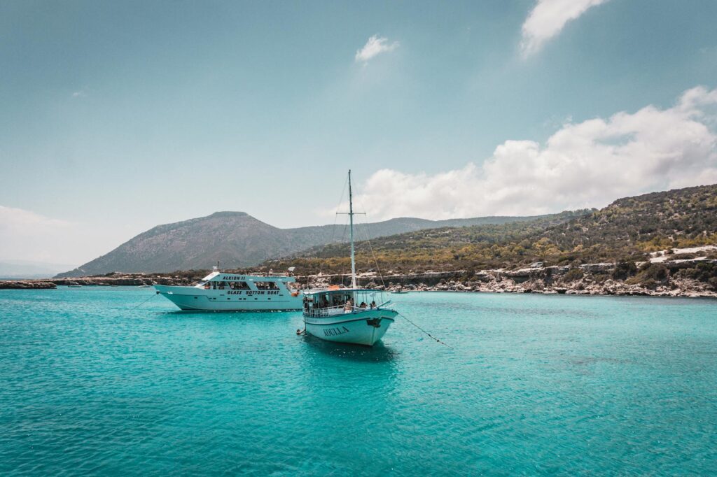 Scenic view of tourist boats floating on turquoise waters near Neo Chorio, Cyprus, under a clear sky.