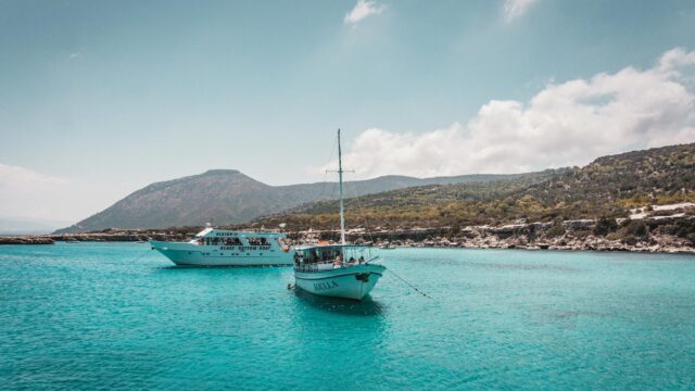 Scenic view of tourist boats floating on turquoise waters near Neo Chorio, Cyprus, under a clear sky.